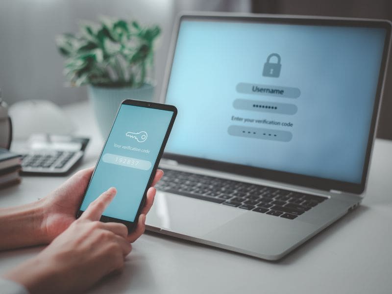 A person checking emails on a laptop with a warning icon, representing phishing threats. My Tampa IT offers the SECURE method to prevent email scams.